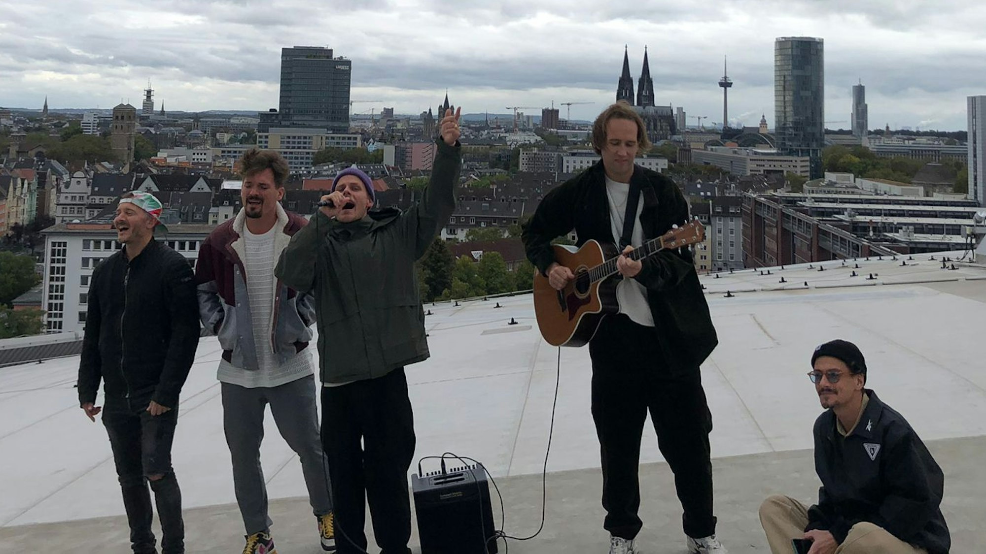 Die Bandmitglieder singen auf dem Dach der Lanxess-Arena.
