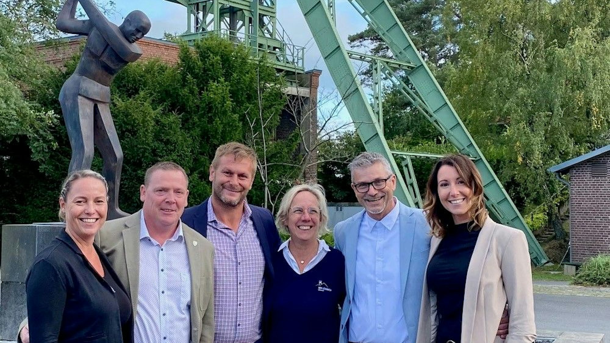 Christiane Peters, Norbert Peters, Sabina Henrich, Ralf Fritz, Manfred Zander und Daniela Zander stehen vor dem Förderturm auf dem Lüderich.