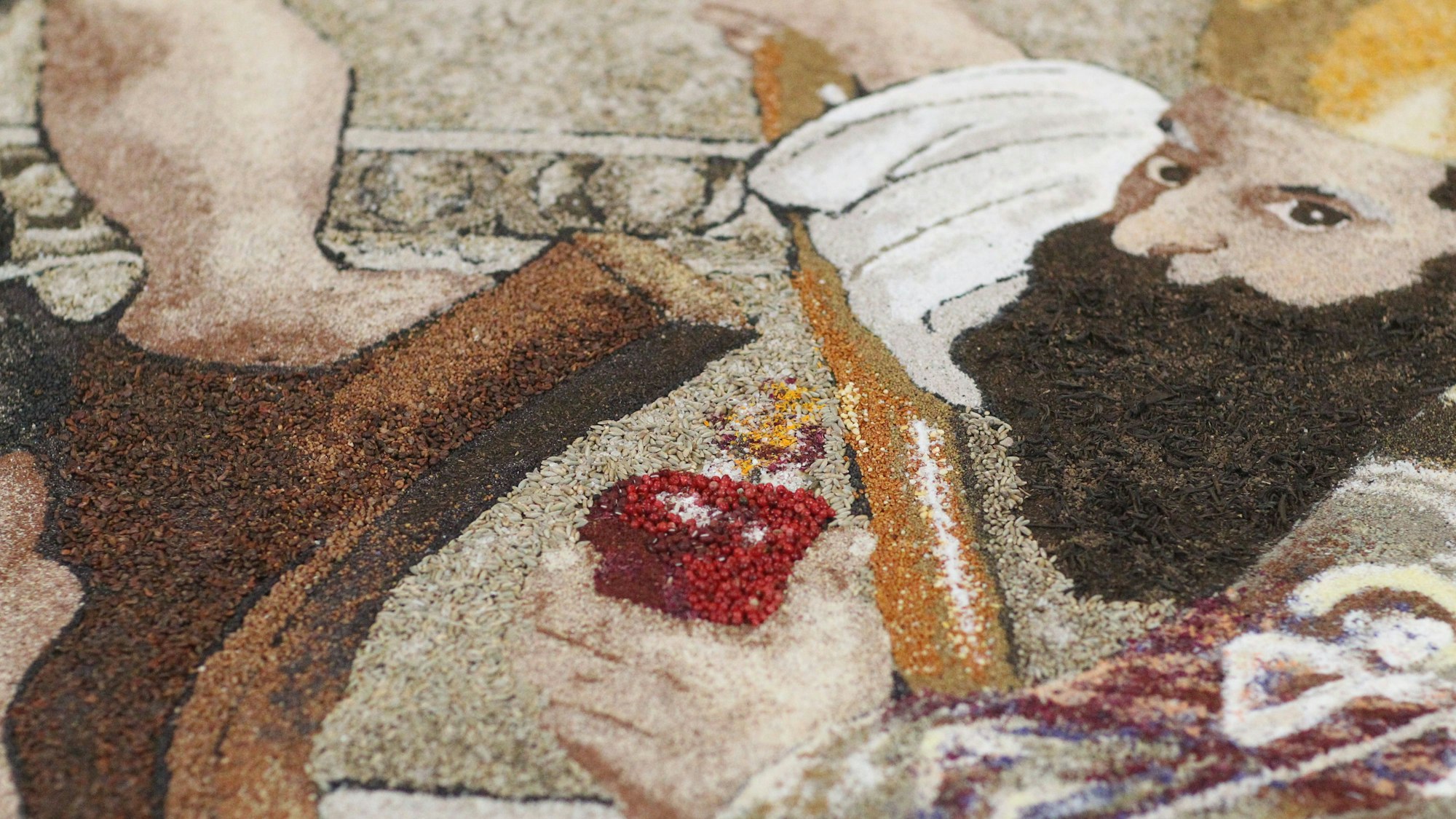 Ein Ausschnitt aus dem Erntedank-Teppich mit einem Gesicht.