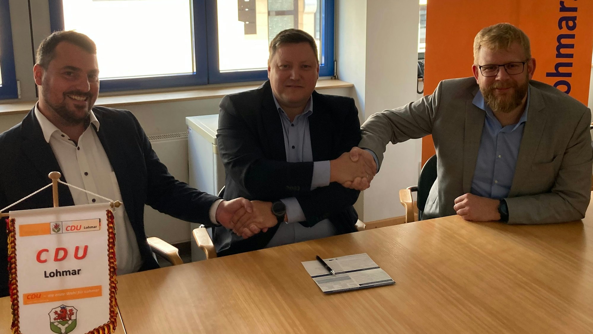Drei Männer an einem Tisch, darauf ein Parteifähnchen der CDU Lohmar