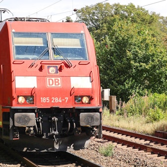 Eine Lokomotive zieht Güterzüge hinter sich her.