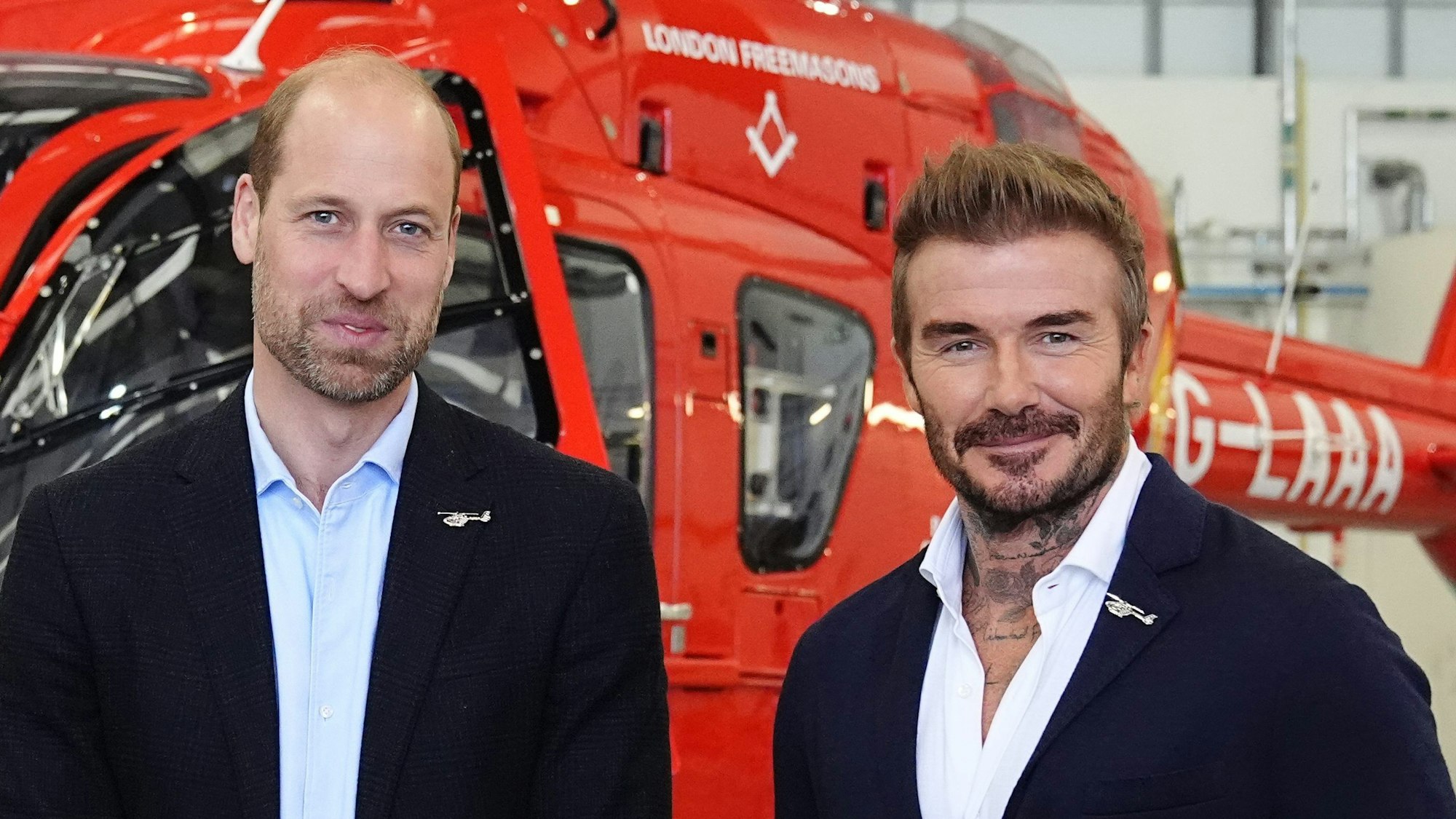 Prinz William posiert mit David Beckham vor einem der neuen Hubschrauber der London Air Ambulance Charity.