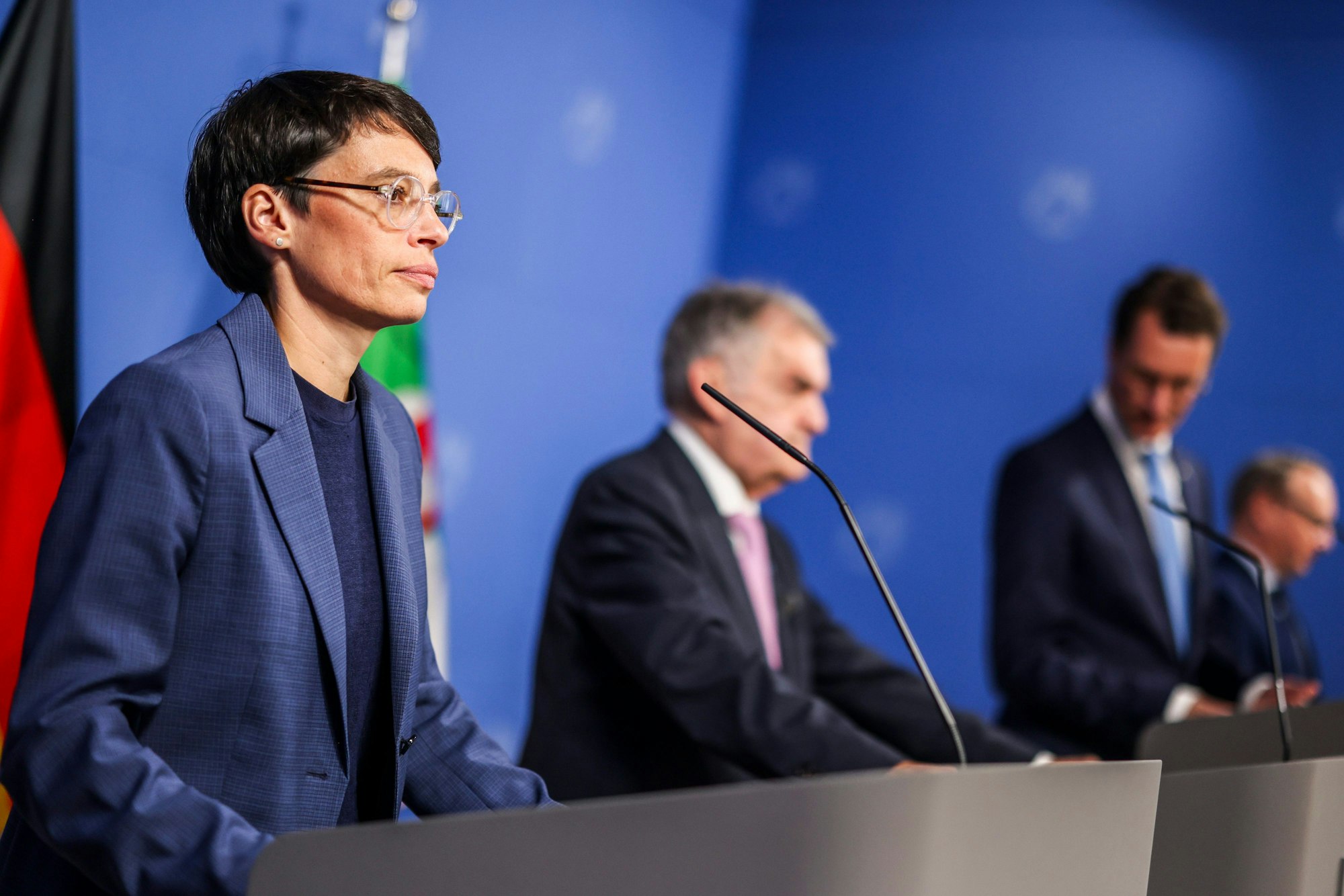 Josefine Paul, NRW-Innenminister Herbert Reul (CDU) und  Ministerpräsident Hendrik Wüst (CDU) bei einer Pressekonferenz.