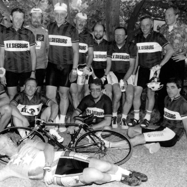 Ein schwarz-weiß-Foto von Männern in Trikots und einem Fahrrad.