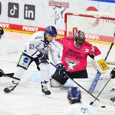 Danjo Leonhardt (l., Straubing) am Donnerstag (3. Oktober) im Zweikampf mit Veli-Matti Vittasmäki vor dem Tor von Julius Hudacek (Kölner Haie).
