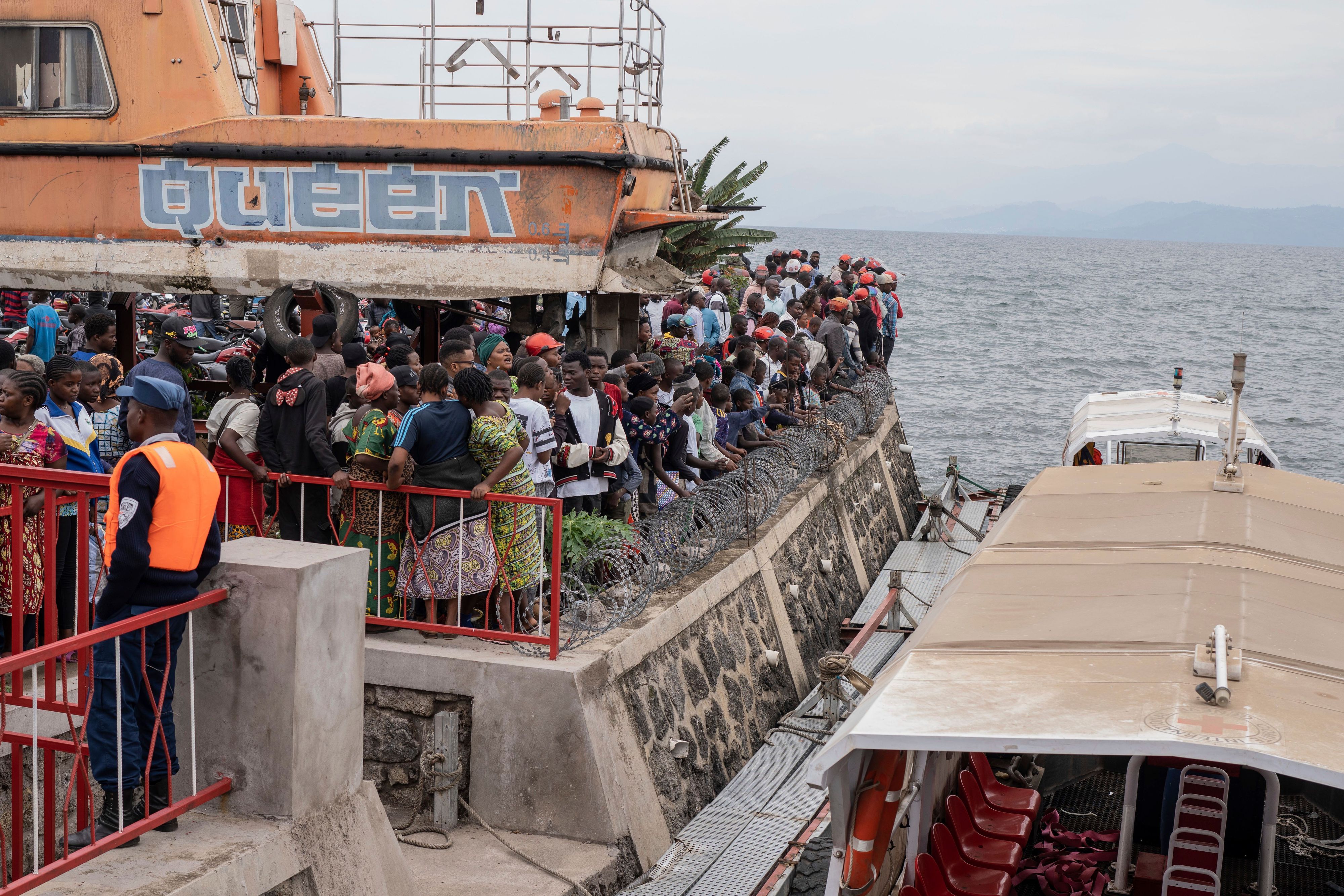 Menschen versammeln sich im Hafen von Goma, nachdem das Schiff bei der Ankunft gekentert ist.
