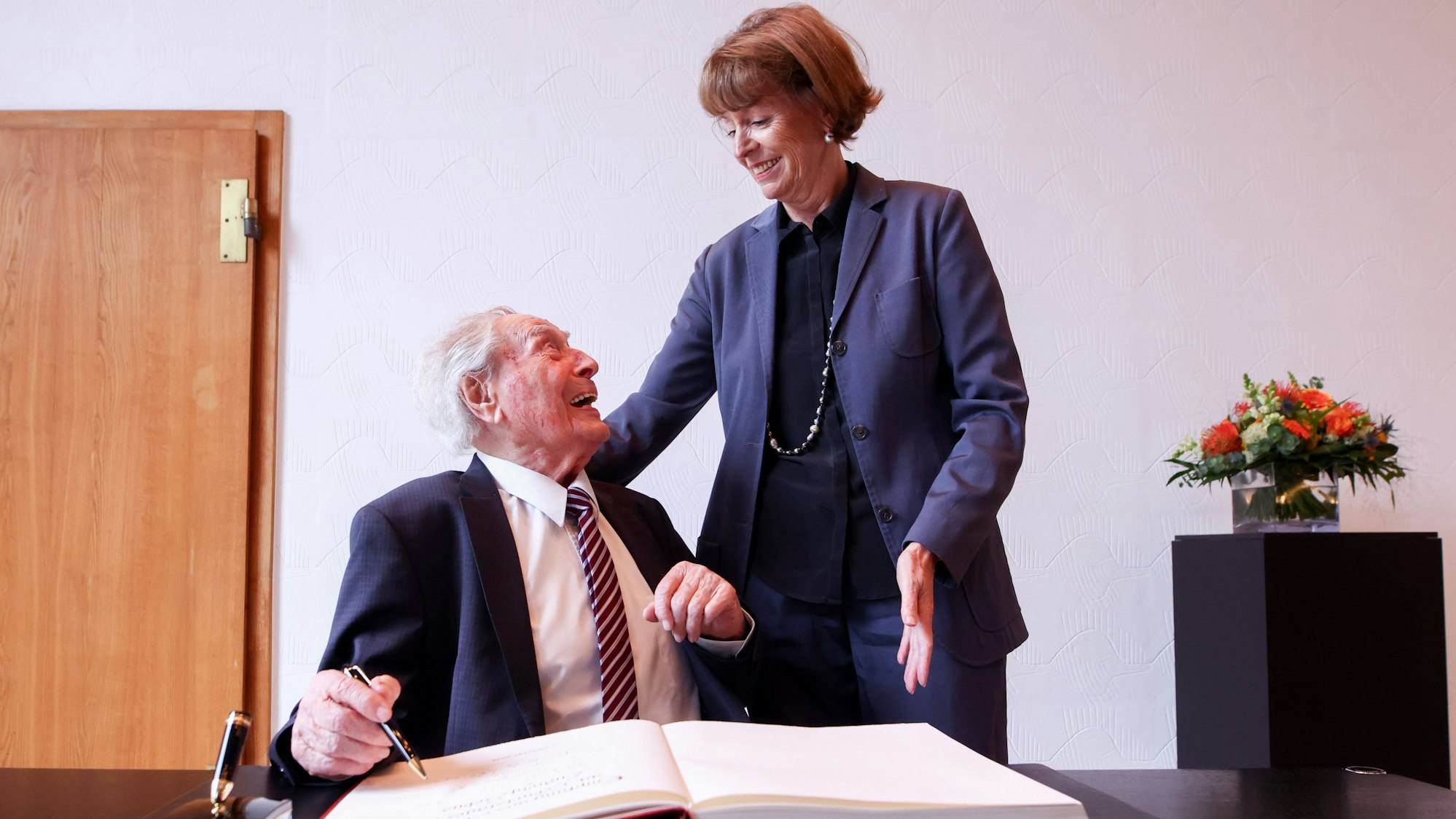 13.09.2024, Köln: Empfang bei Oberbürgermeisterin Henriette Reker zum 99. Geburtstags von Ludwig Sebus im Historischen Rathaus in Köln - Ludwig Sebus beim Eintrag ins Gästebuch der Stadt mit OB Reker. Foto: Thilo Schmülgen