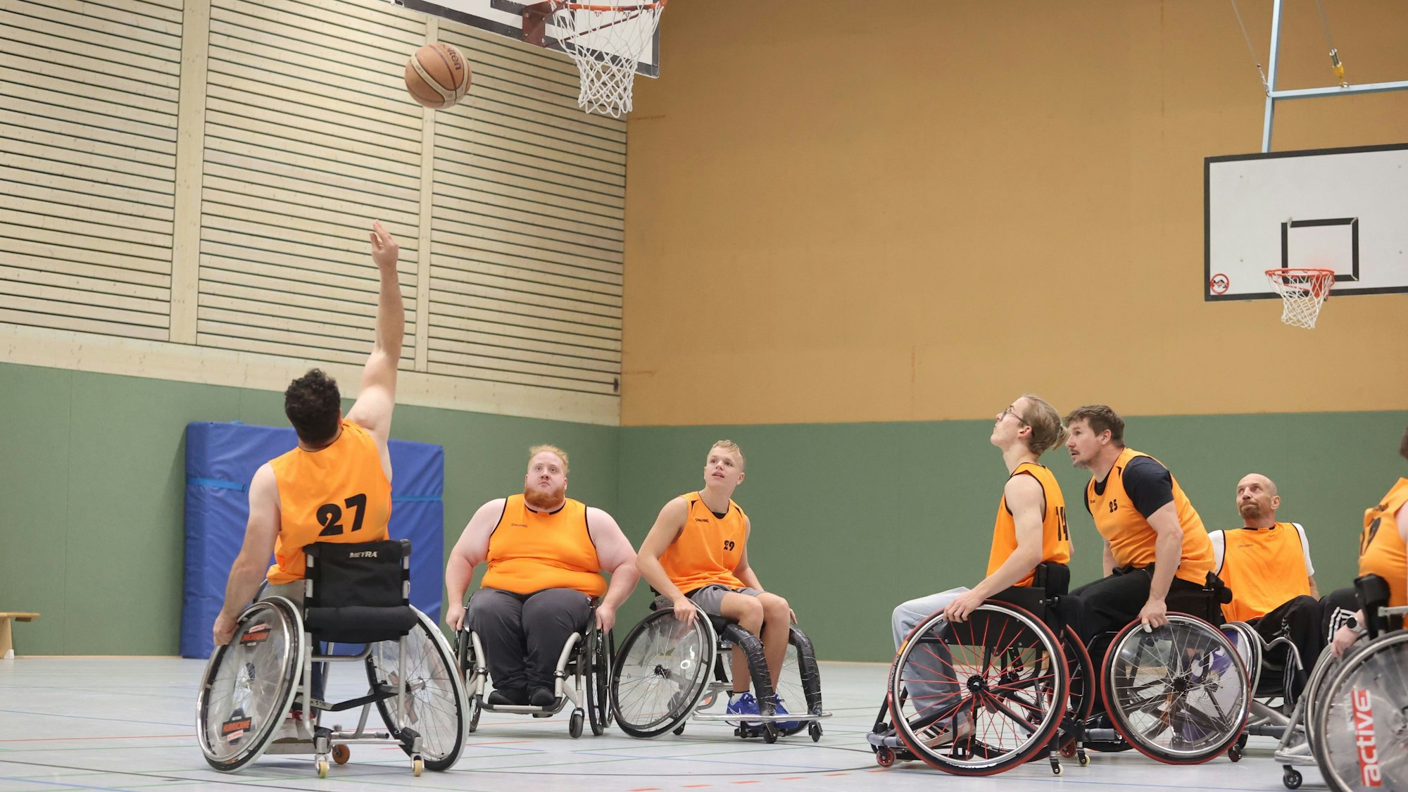 Mehrere Rollstuhlbasketballer beim Training.