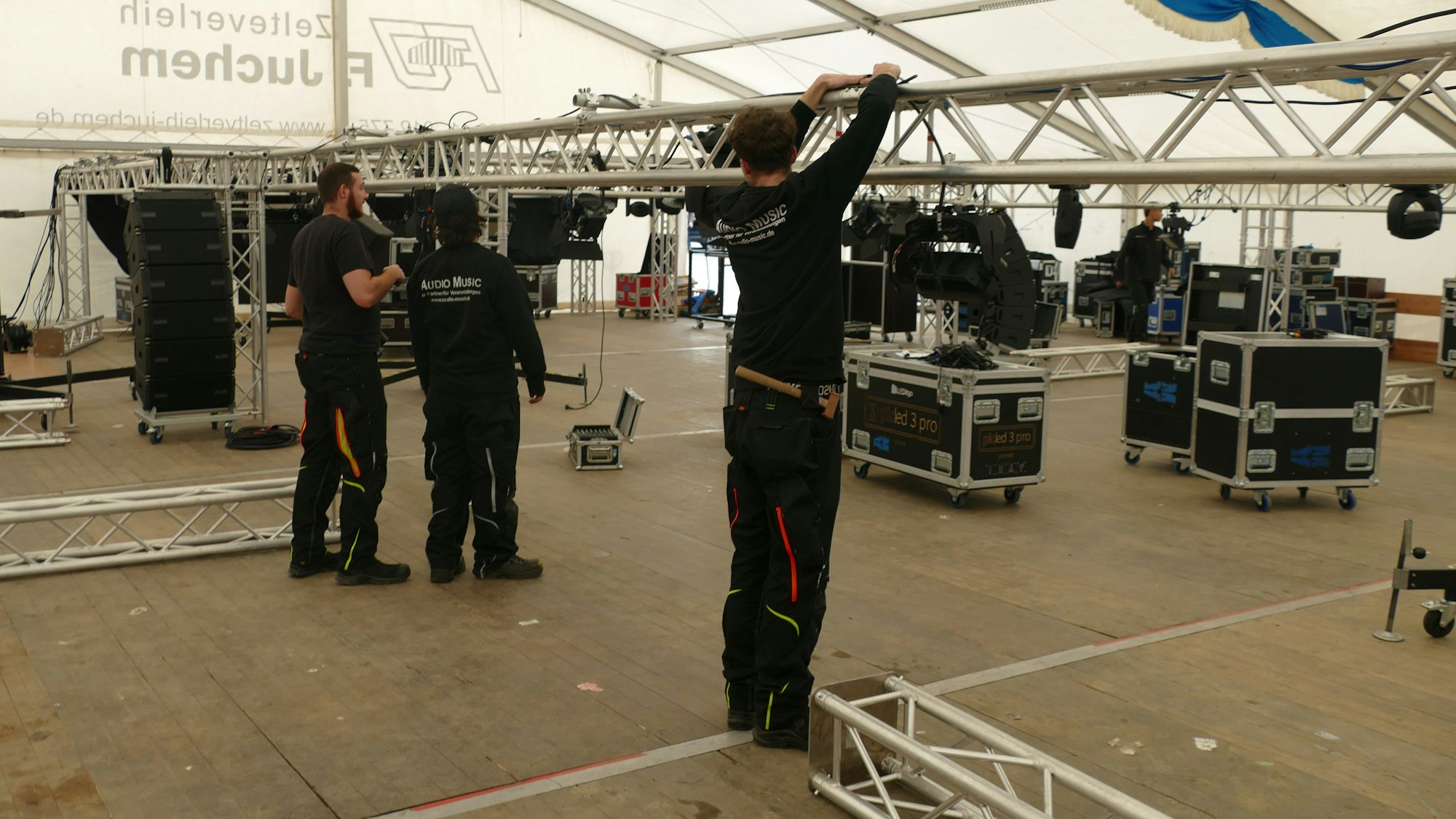 Arbeiter bauen Technik auf.