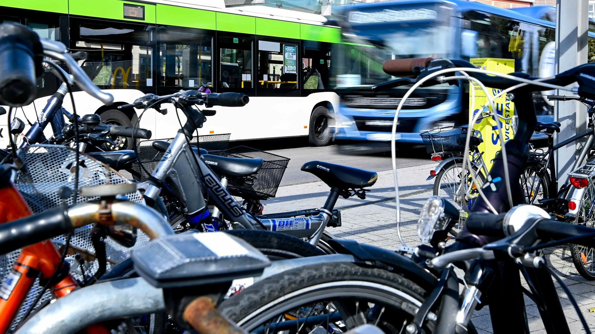 Das Bild zeigt einen abfahrenden Bus am Euskirchener Bahnhof. Im Vordergrund stehen einige Fahrräder.