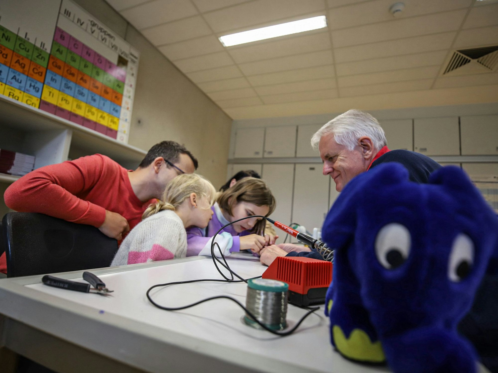 Eine Familie baut sich mit einem Bausatz einen leuchtenden Käfer zusammen. Sie war Gast beim bundesweiten Aktionstag „Türen auf mit der Maus“.