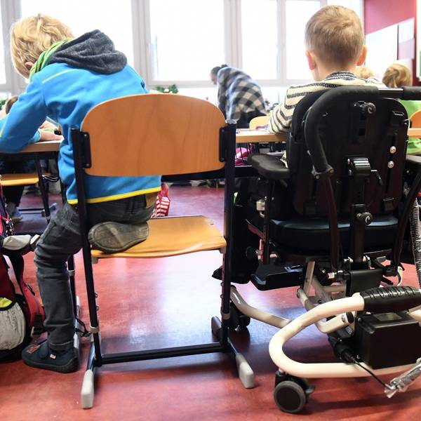 Ein Kind mit Behinderung sitzt in seinem Rollstuhl gemeinsam mit anderen Erstklässlern ohne Handicap in einem Klassenraum. Die SPD-Opposition sieht in Nordrhein-Westfalen große Defizite auf dem Weg zur gleichberechtigten gesellschaftliche Teilhabe von Menschen mit Behinderung.