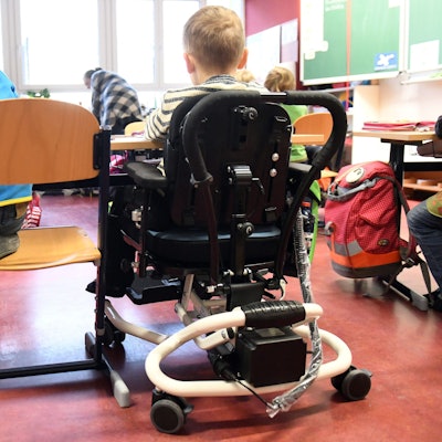 Ein Kind mit Behinderung sitzt in seinem Rollstuhl gemeinsam mit anderen Erstklässlern ohne Handicap in einem Klassenraum. Die SPD-Opposition sieht in Nordrhein-Westfalen große Defizite auf dem Weg zur gleichberechtigten gesellschaftliche Teilhabe von Menschen mit Behinderung.