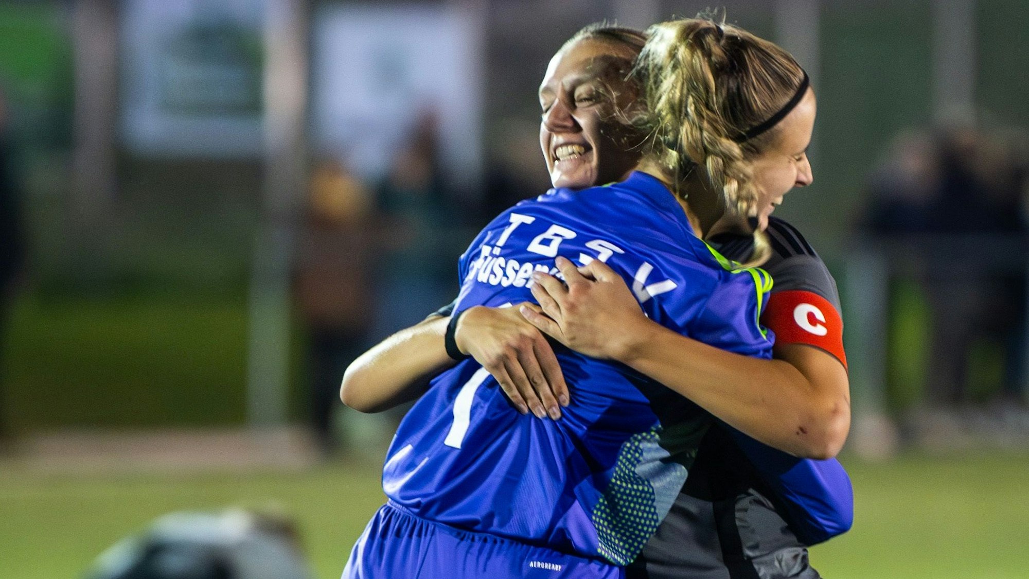 Torhüterin Michelle Leyendecker im blauen Trikot und Kapitänin Anna Bönsch vom TB-SV Füssenich-Geich umarmen sich nach dem Abpfiff.