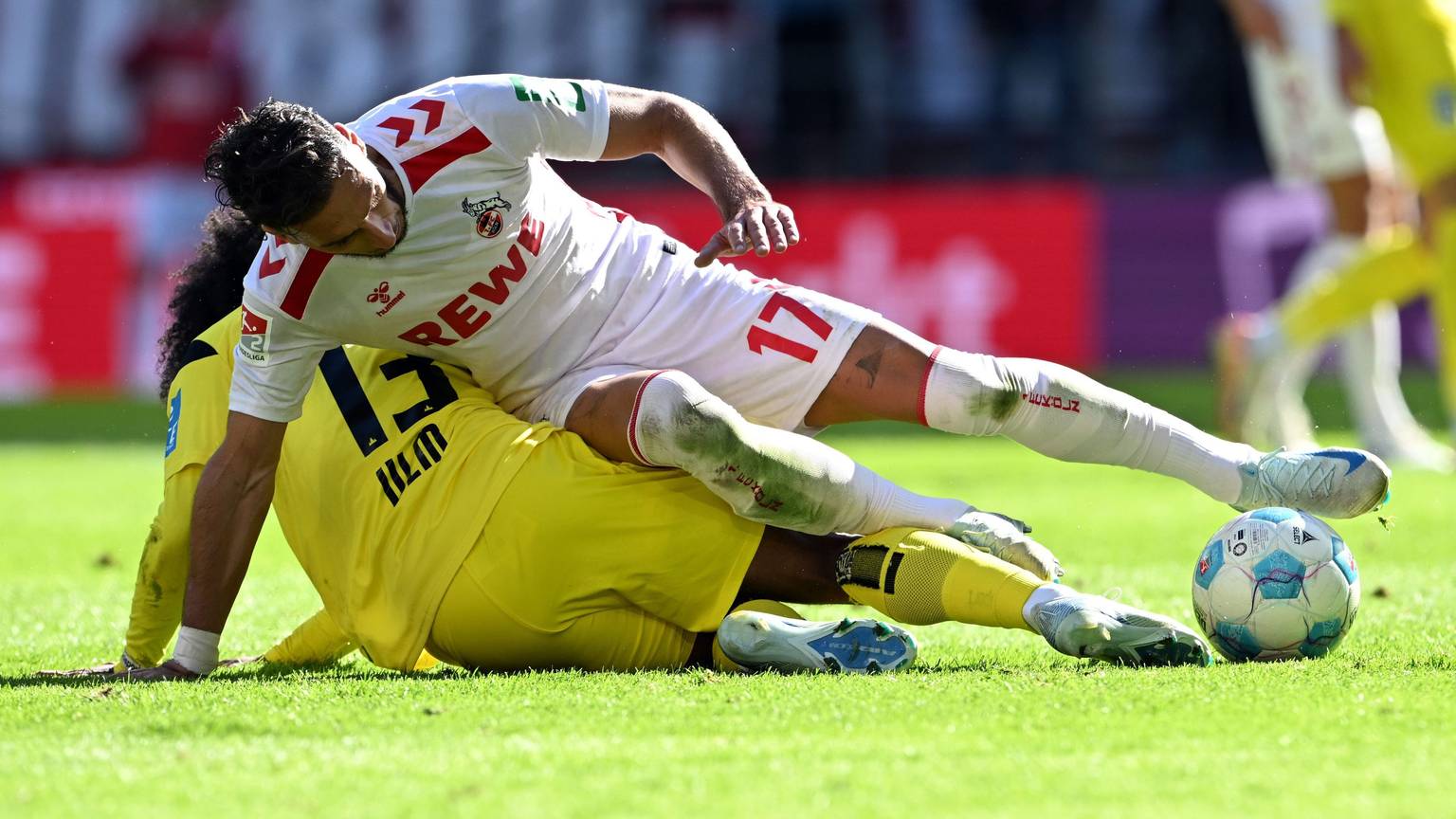Kölns Leart Paqarada und Ulms Jayden Nelson (u,) kämpfen um den Ball.