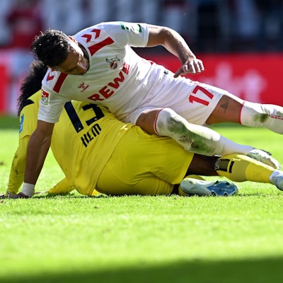 Kölns Leart Paqarada und Ulms Jayden Nelson (u,) kämpfen um den Ball.