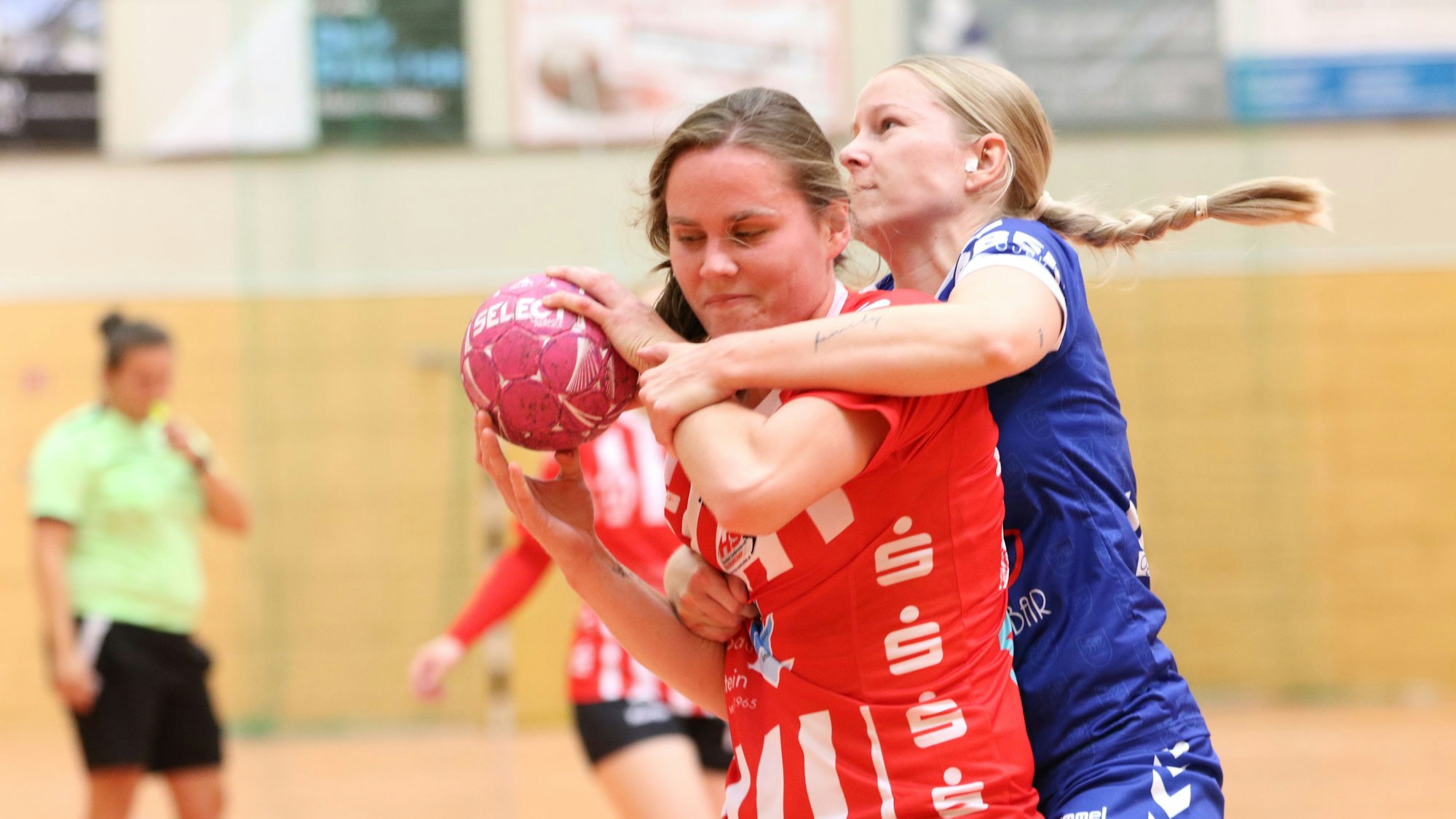 Die Euskirchener Spielerin wird, den Ball in der Hand, von ihrer Gegnerin unsanft gestoppt.