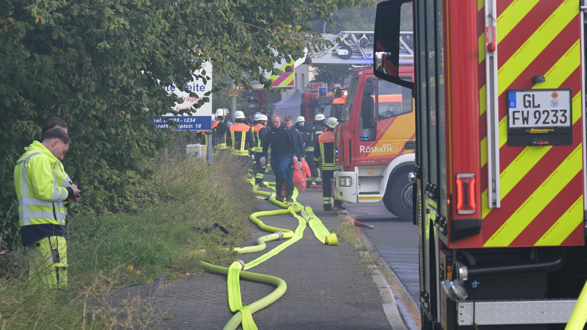 Feuerwehreinsatzfahrzeuge und -leute stehen an der Kölner Straße in Rösrath.