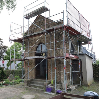 Ein kleines Backsteingebäude ist eingerüstet.