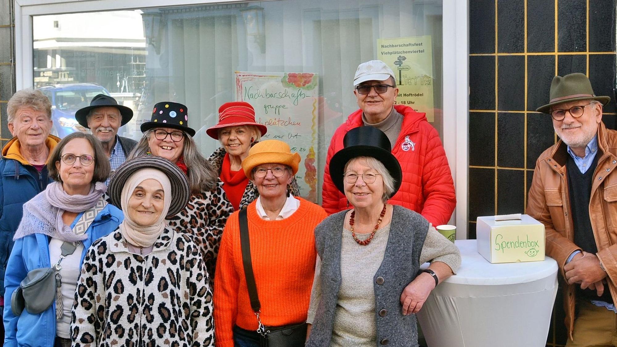 Eine Gruppe von Frauen und Männern steht vor einem Gebäude.