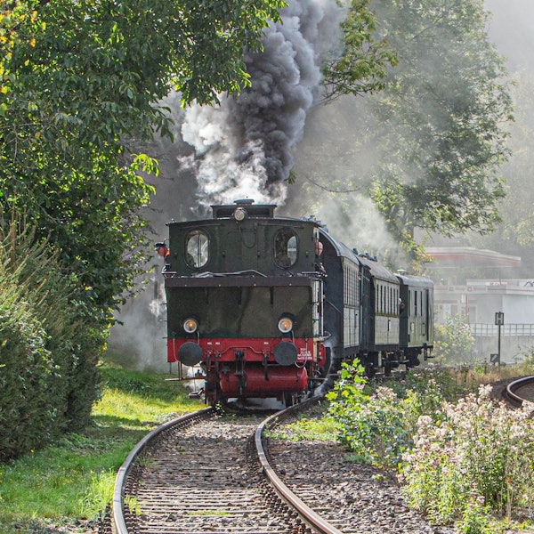 Die Dampflok Waldbröl rangiert auf dem Gleisabschnitt in Engelskirchen-Osberghausen, Dampf steigt aus dem Schornsein der Lok auf.