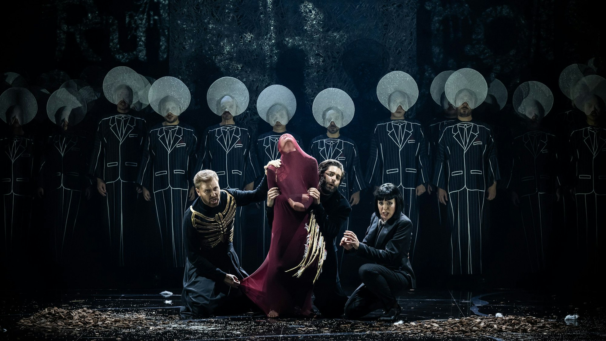 Die anderen Engel – Uriel (Sebastian Kohlhepp, l.), Rafael (Alex Rosen) und Gabriel (Kathrin Zukowski) – ringen mit Satan (Francesca Merolla ). Im Hintergrund der Chor der Oper Köln.