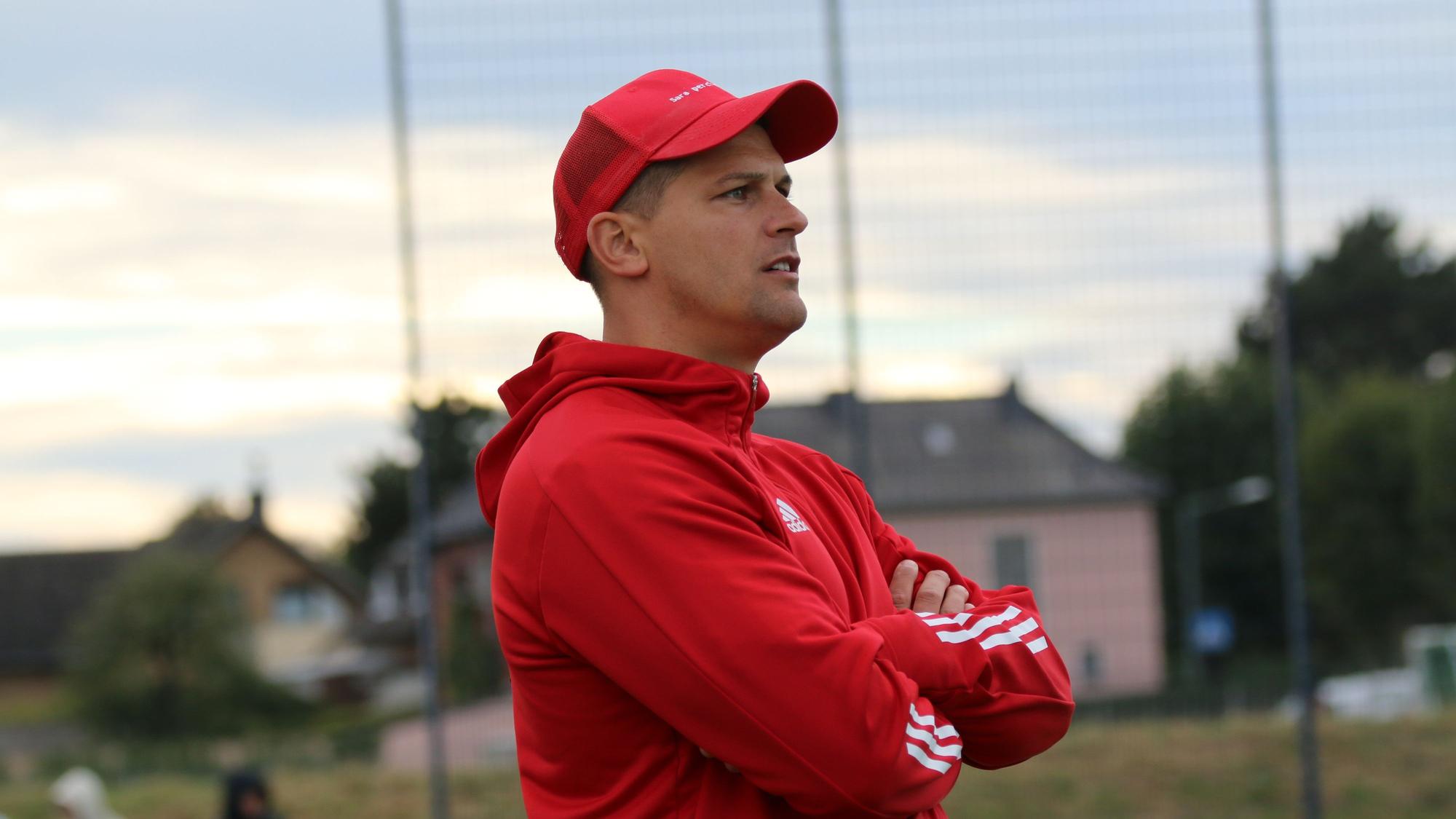 Der Trainer steht am Spielfeldrand und beobachtet die Begegnung.