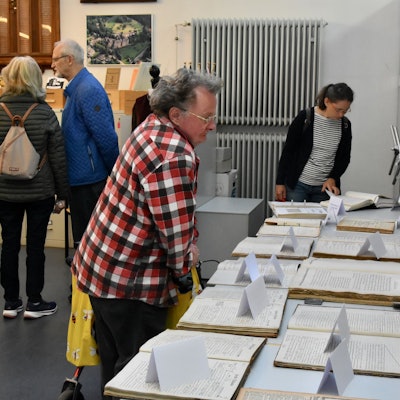 Menschen beugen sich über Papiere.