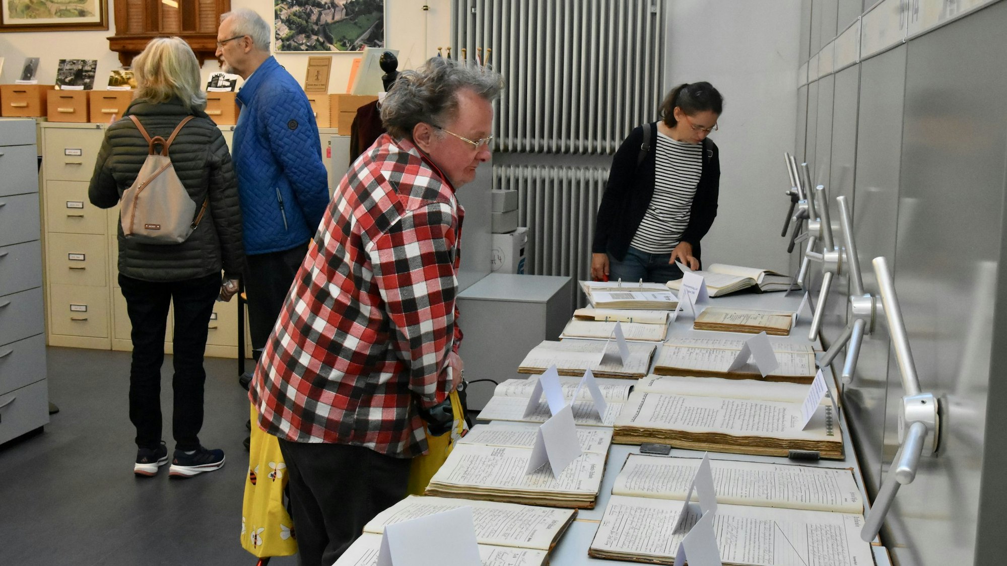 Menschen beugen sich über Papiere.