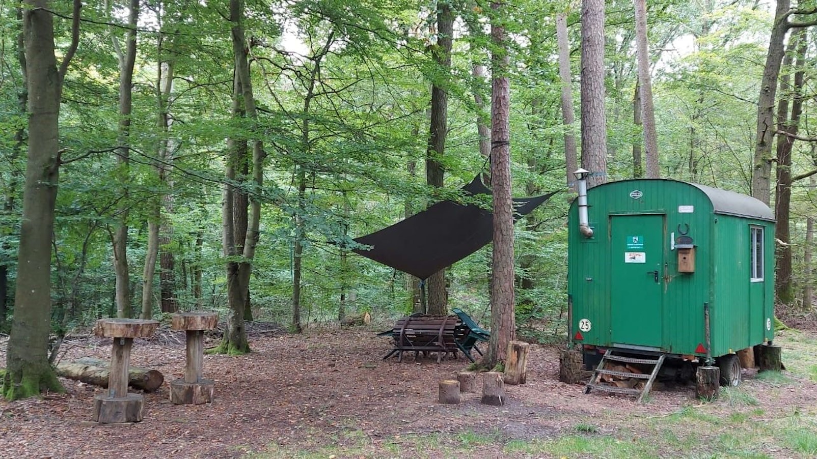Ein grüner Bauwagen der Waldarbeiter steht in einem Waldstück bei Blankenheim-Dollendorf.