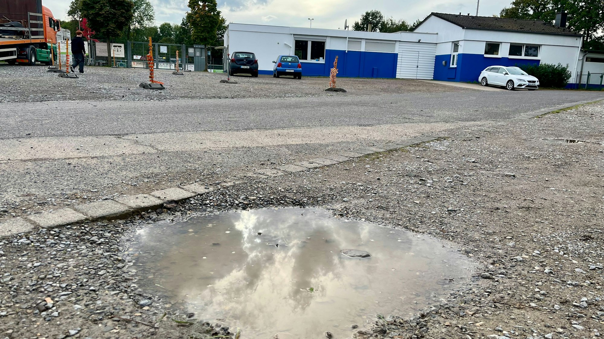 Pfütze auf Schotterparkplatz