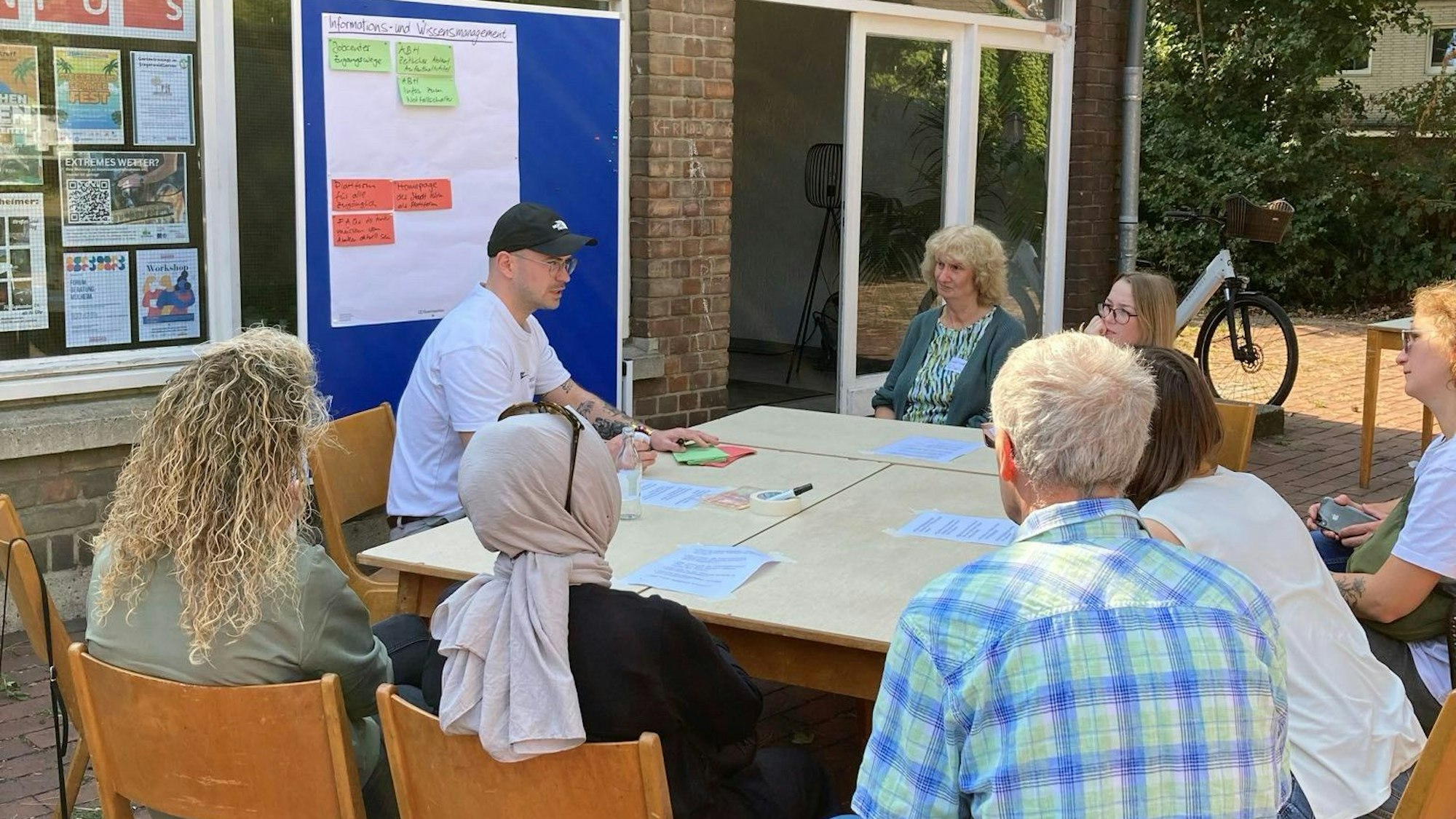 Menschen sitzen an einem Tisch zusammen