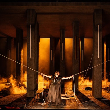 Elektra verendet an zwei Seilen, an die sie zwei überlebende Opfer des Massakers an Aegisths Gefolgschaft mit letzter Kraft gebunden haben.