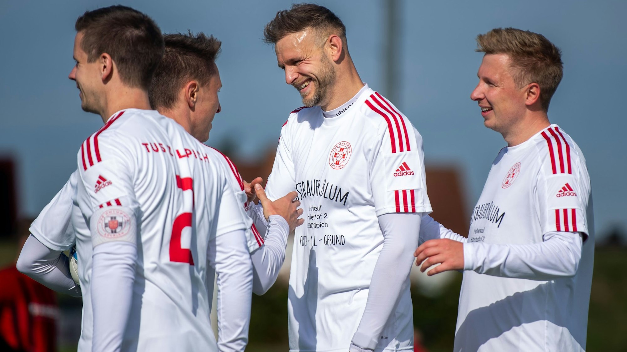 Das Bild zeigt vier Spieler des TuS Zülpich, die sich über einen Treffer freuen.