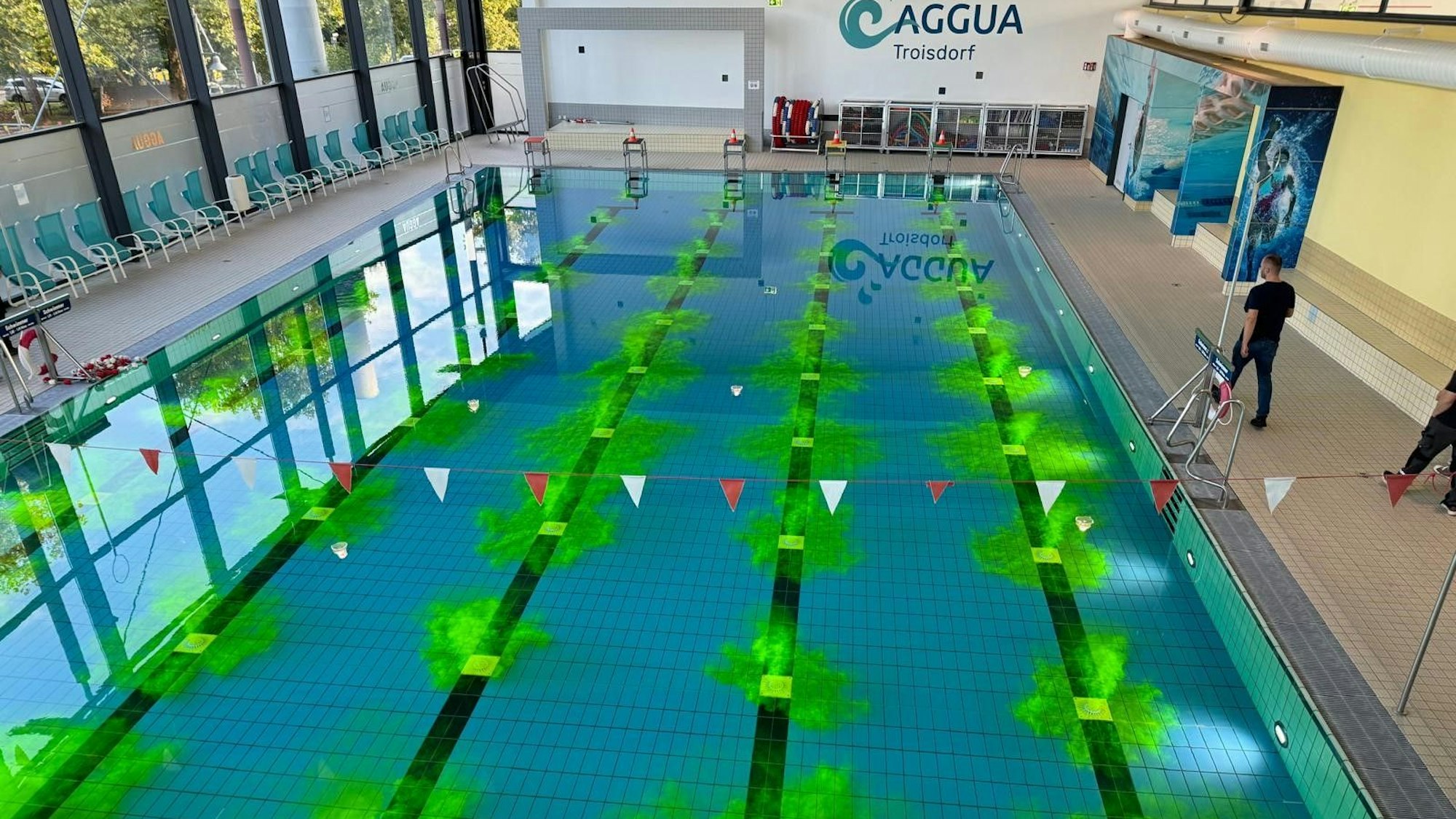 In einem Schwimmbecken färbt sich das Wasser an den Bodendüsen grün.