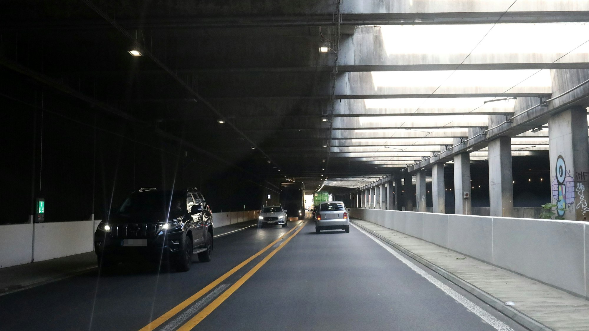 Fahrzeuge fahren durch einen Tunnel.