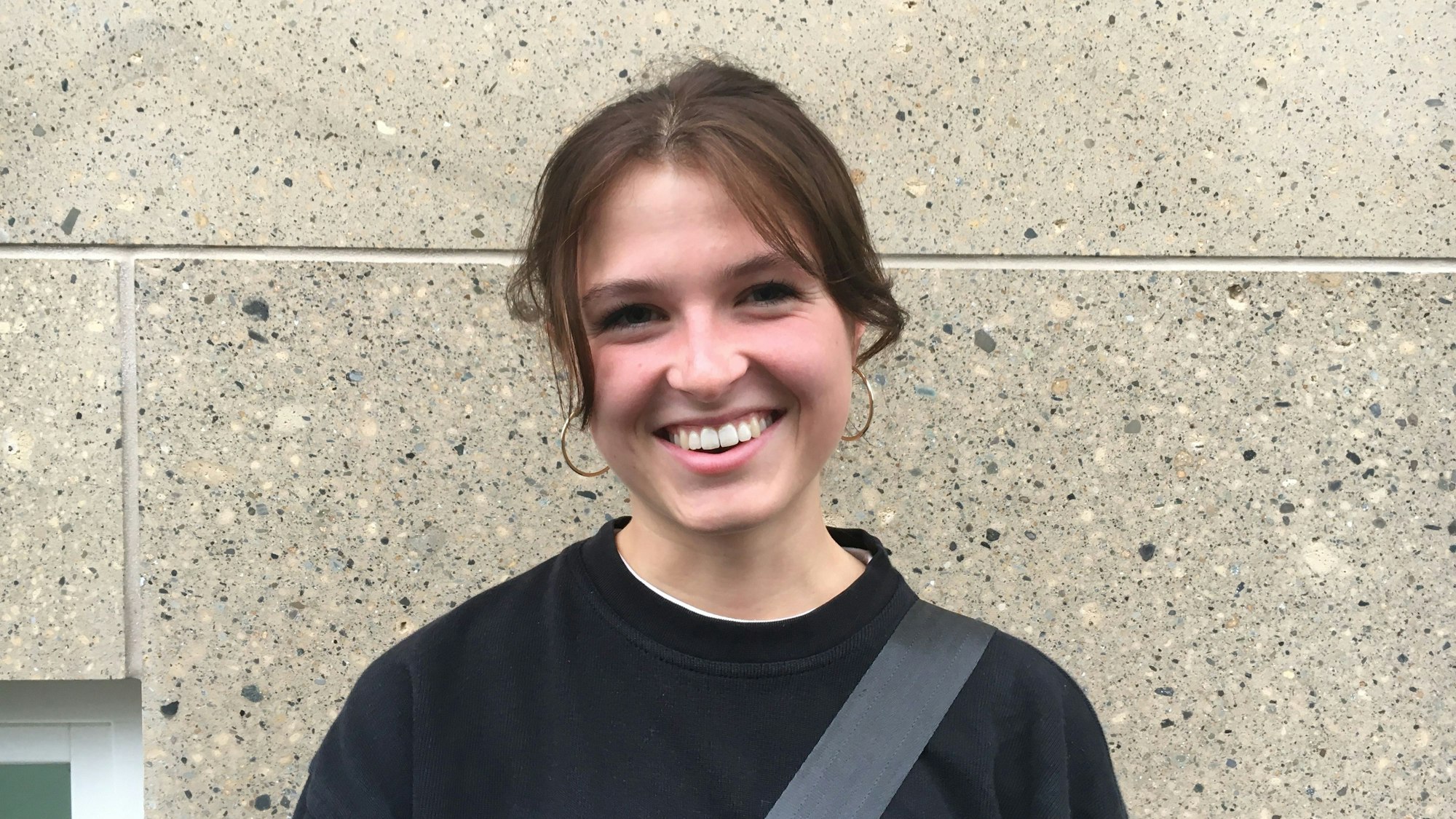 Eine Studentin lacht in die Kamera