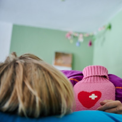 Ein Kind liegt mit Wärmflasche im Bett.
Wer eine Erkältung hat, braucht Ruhe.