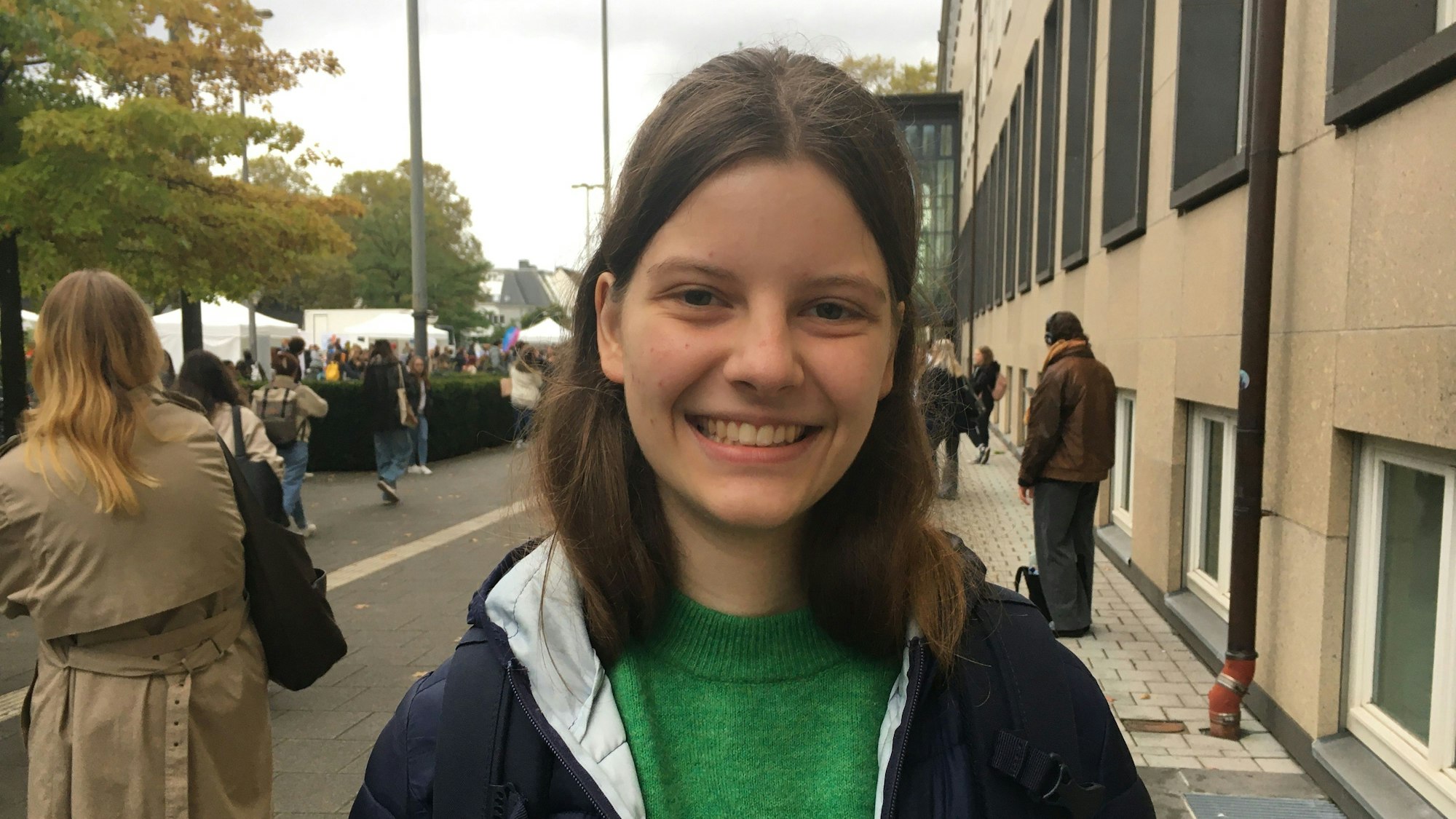 Eine Studentin lacht in die Kamera.