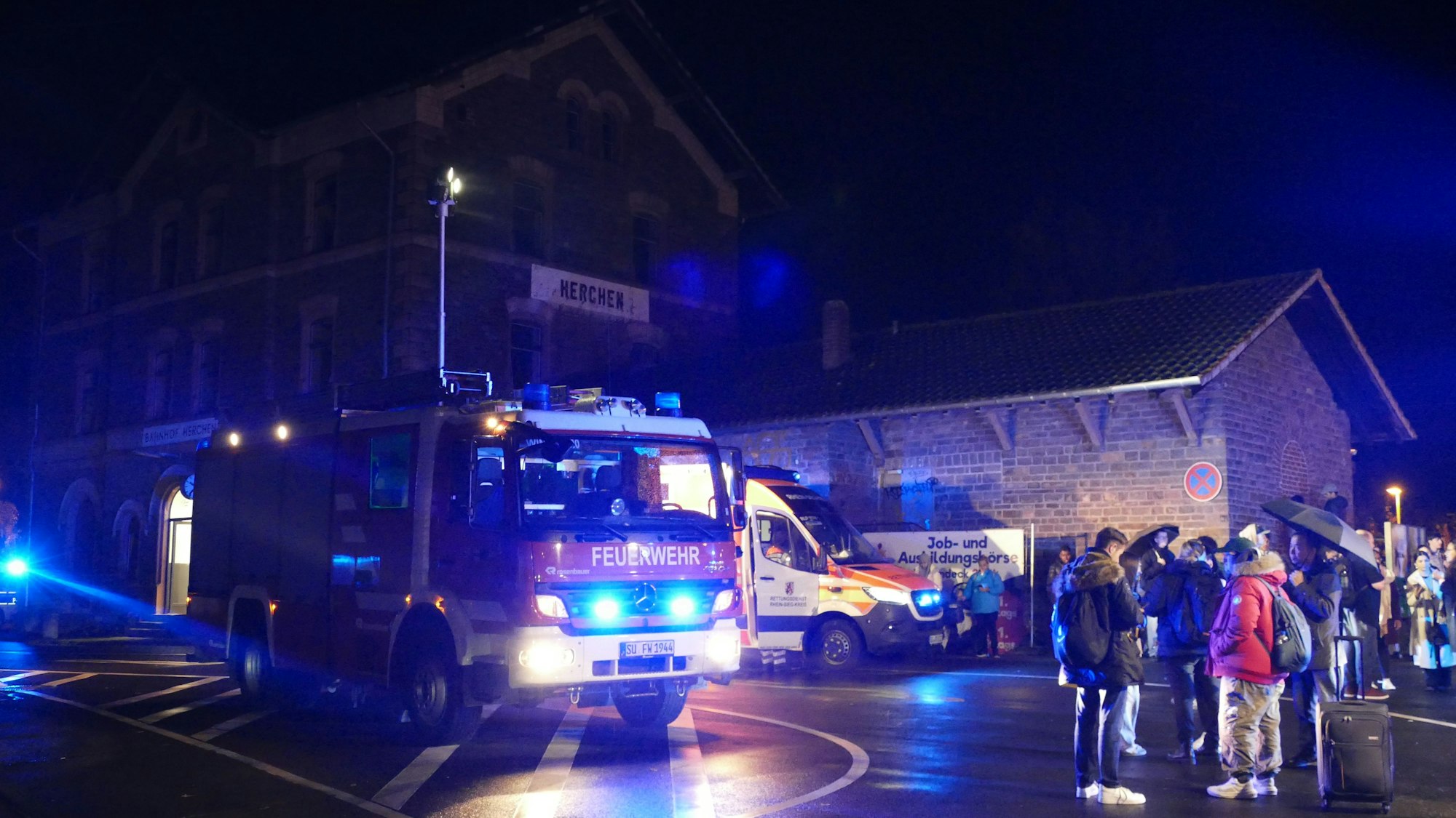 Ein Feuerwehrauto steht vor einem Bahnhofsgebäude.