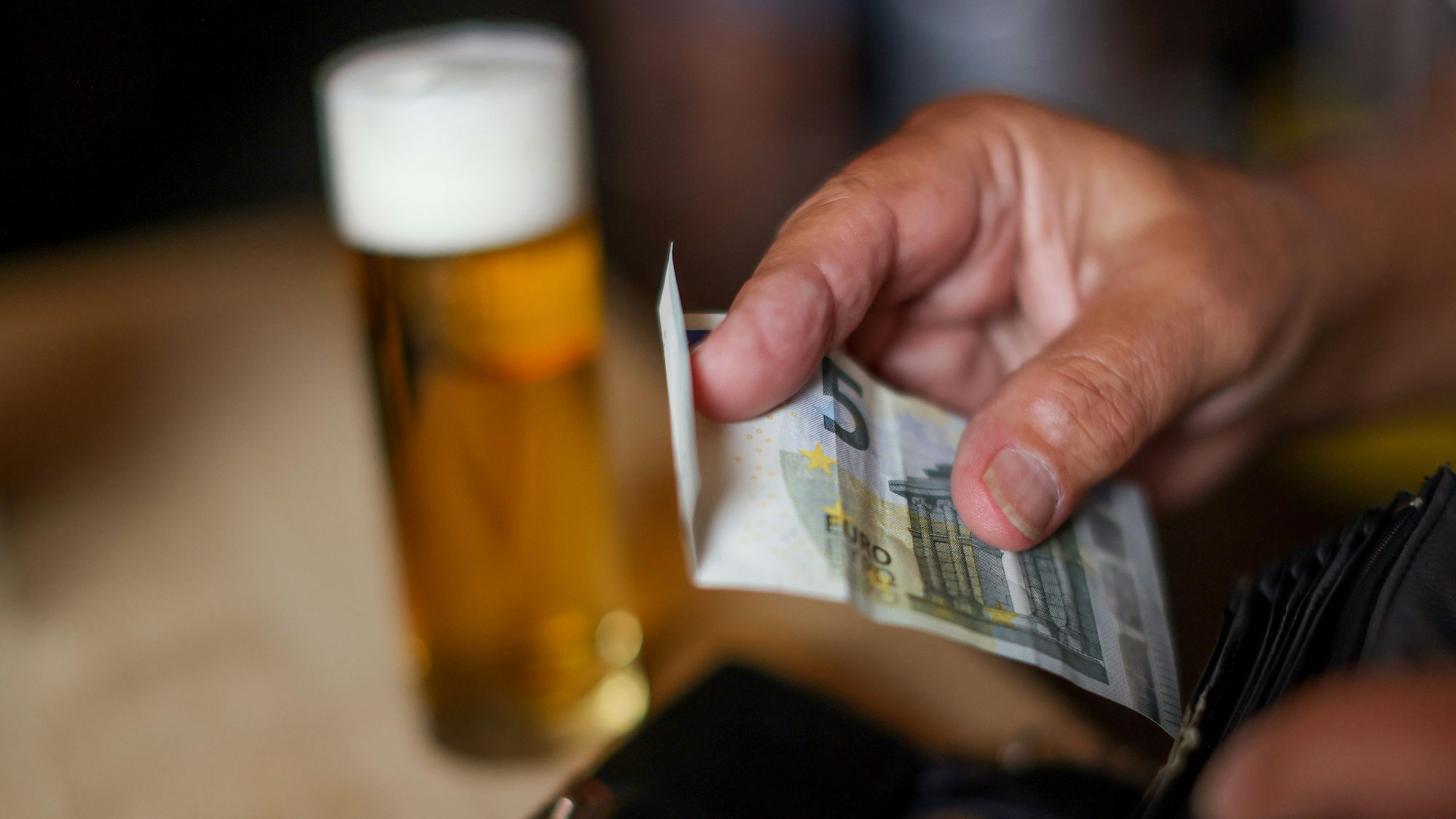 Symbolfoto zum Thema Trinkgeld mit Geldscheinen, Münzen und einem Kölsch in einem Brauhaus in Köln.