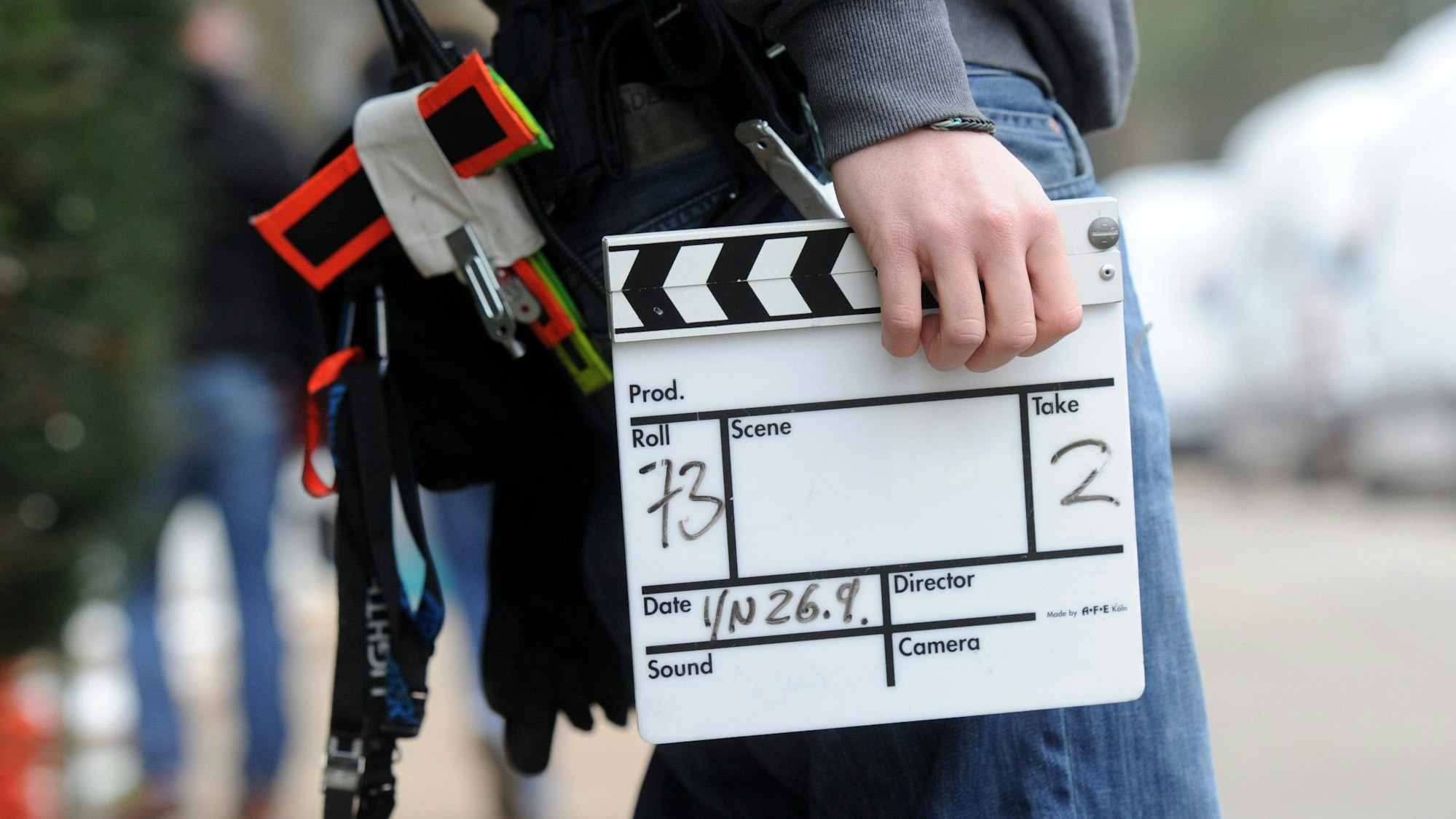 Ein Mitarbeiter eines Filmteams hält eine Filmklappe.