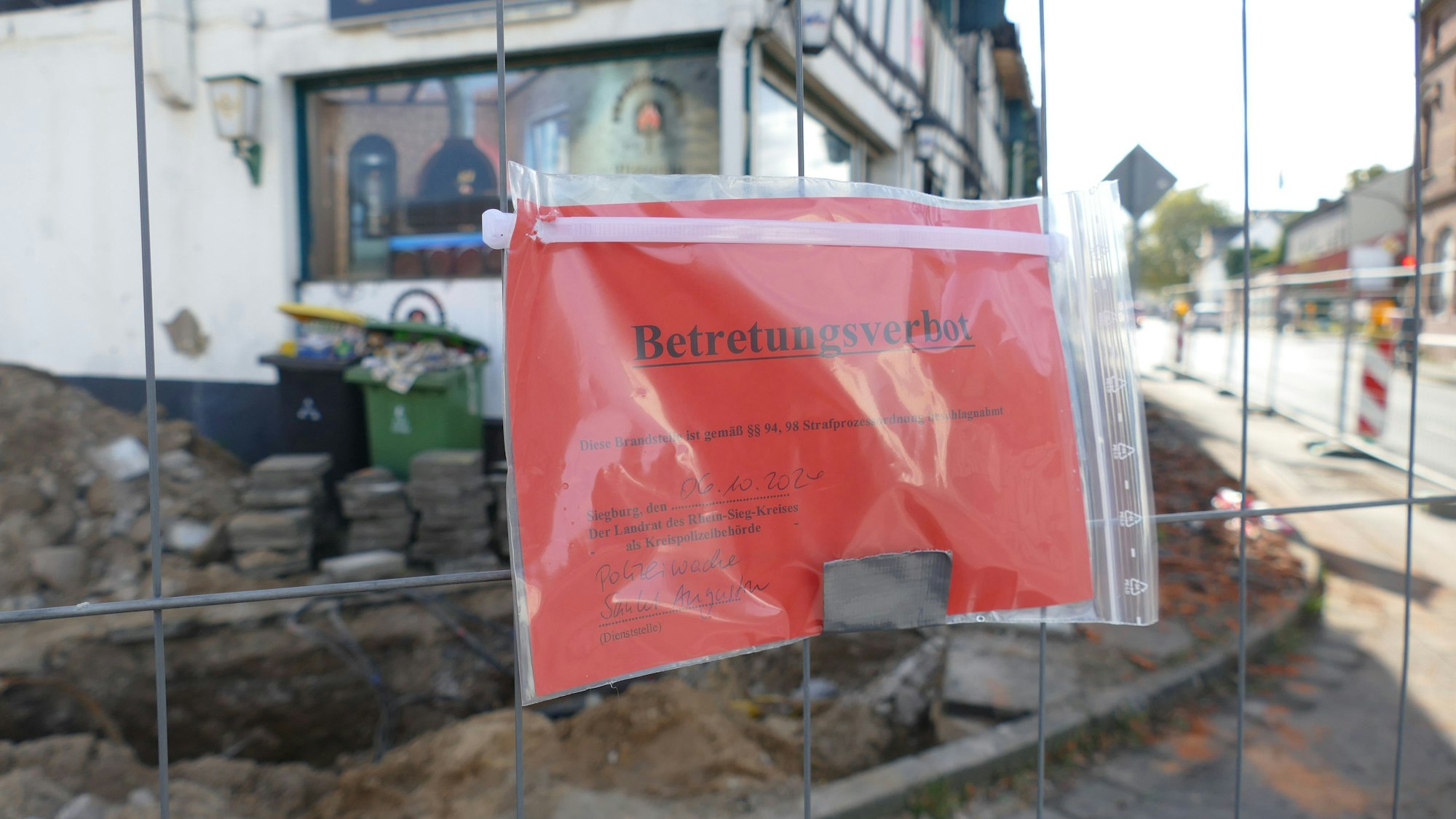 Die Polizei hat ein Schild am Zaun um die Brandruine aufgehängt.