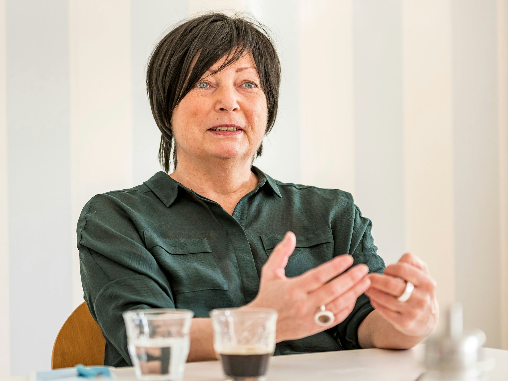 Martina Richter sitzt an einem Tisch und gestikuliert.