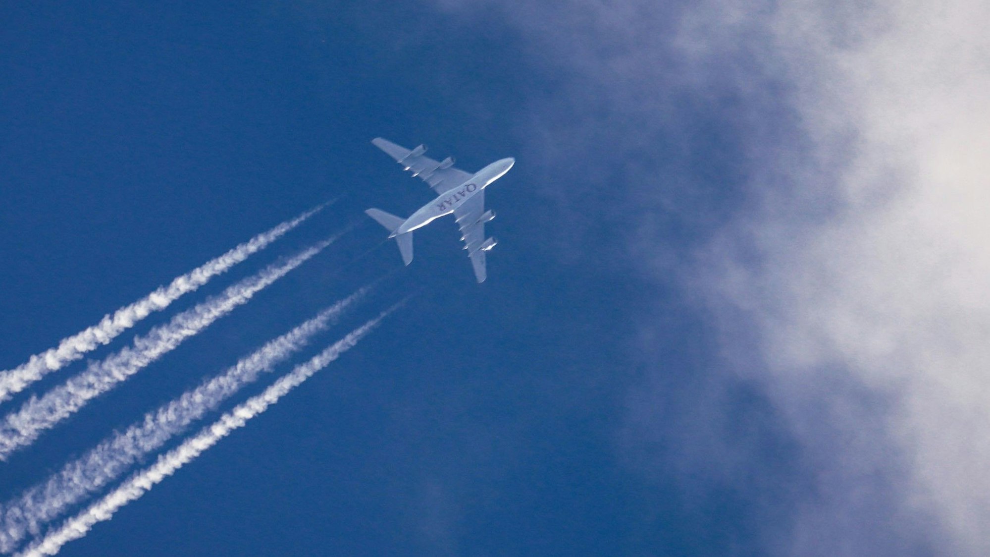 Ein Airbus A380 der Qatar Airways aus dem Emirat Katar fliegt am weitgehend blauen Himmel über Frankfurt hinweg.