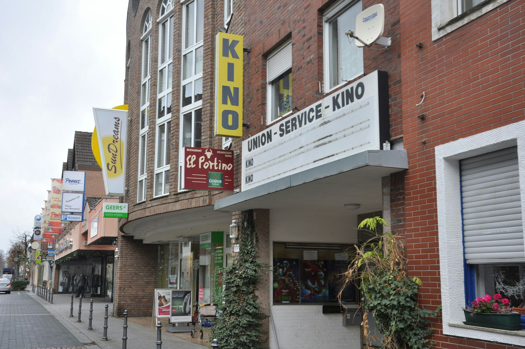 Zu sehen ist ein Gebäude aus Backstein, ein gelbes Schild weist auf ein Kino hin.