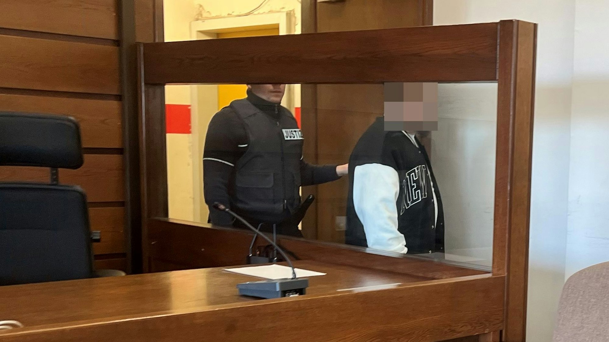 Ein Wachtmeister führt den Angeklagten in Saal 112 des Kölner Landgerichts.