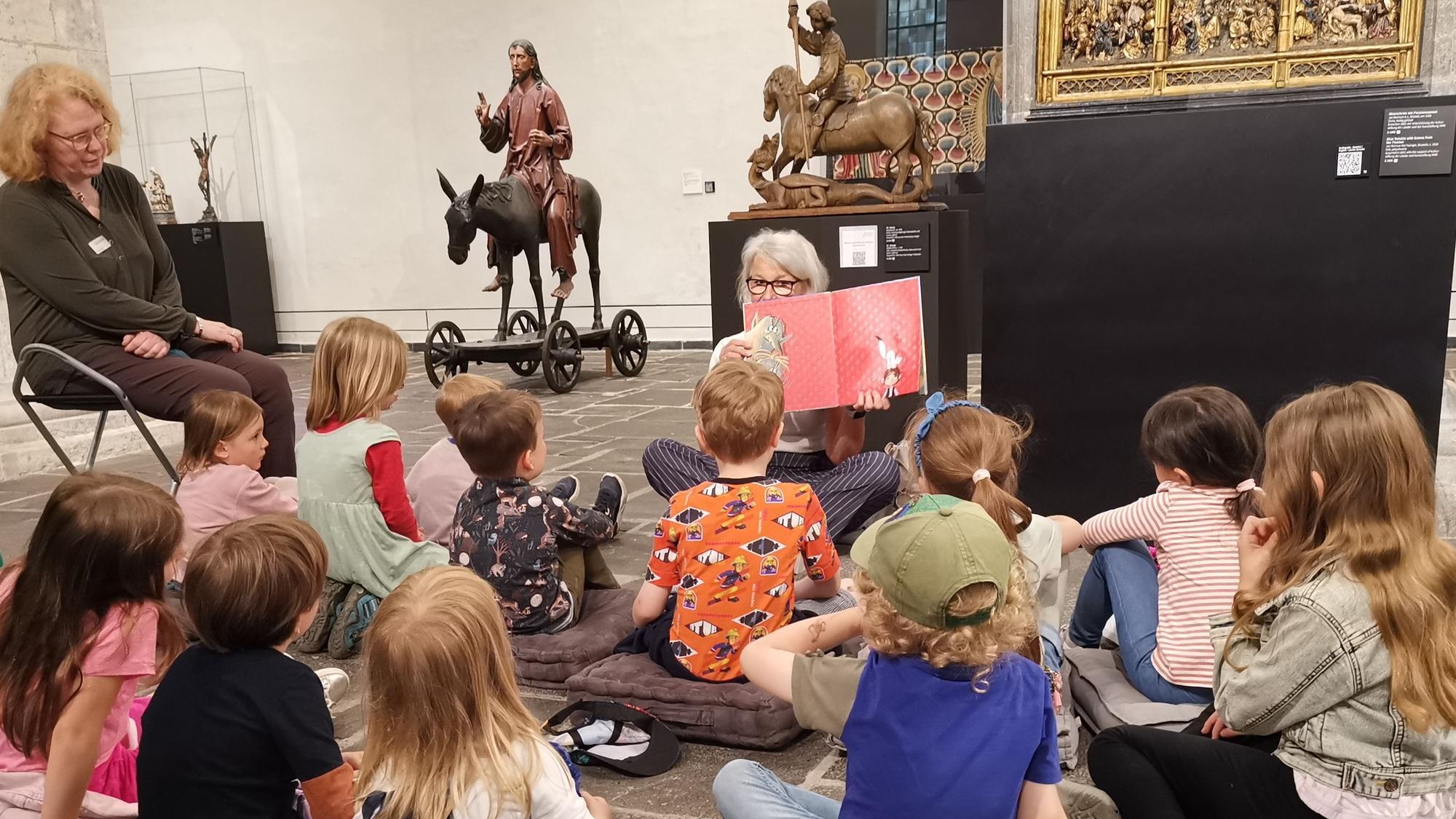 Ehrenamtlerinnen lesen Kindern im Museum vor.