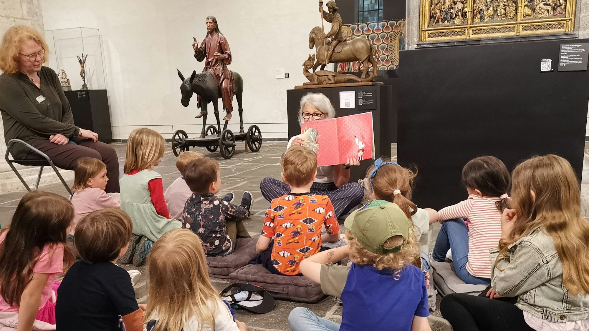 Ehrenamtlerinnen lesen Kindern im Museum vor.