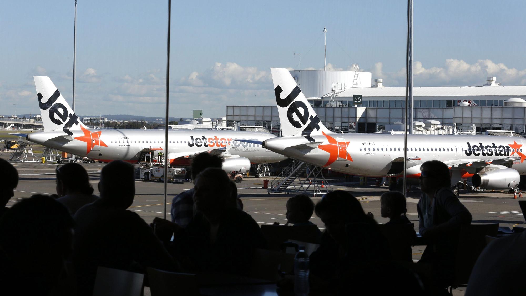Flugzeuge der australischen Billigfluglinie Jetstar stehen auf einem Flughafen am Terminal.